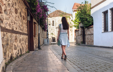 Young girl tourist walking through the deserted streets of the old town of Kaleici in Antalya