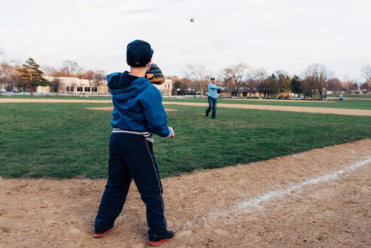 Father pitching from a mound to his son