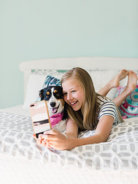 Young girl taking selfie with her pet puppy