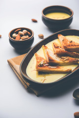 shahi tukra/tukda or Double ka meetha is a bread pudding Indian sweet of fried bread slices soaked in rabid or sweet saffron milk garnished with dry fruits, selective focus