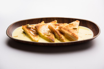 shahi tukra/tukda or Double ka meetha is a bread pudding Indian sweet of fried bread slices soaked in rabid or sweet saffron milk garnished with dry fruits, selective focus