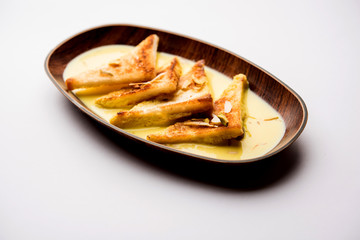 shahi tukra/tukda or Double ka meetha is a bread pudding Indian sweet of fried bread slices soaked in rabid or sweet saffron milk garnished with dry fruits, selective focus