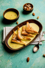 shahi tukra/tukda or Double ka meetha is a bread pudding Indian sweet of fried bread slices soaked in rabid or sweet saffron milk garnished with dry fruits, selective focus