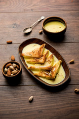 shahi tukra/tukda or Double ka meetha is a bread pudding Indian sweet of fried bread slices soaked in rabid or sweet saffron milk garnished with dry fruits, selective focus
