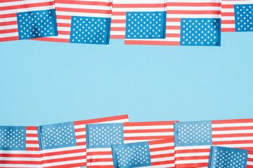 Fototapeta premium frame of american flags on blue background with copy space
