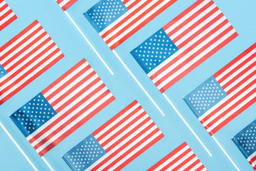 flat lay with national  american flags on sticks on blue background