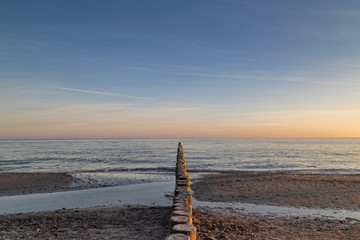 Groynes leading into the sea at sunrise