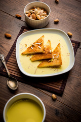 shahi tukra/tukda or Double ka meetha is a bread pudding Indian sweet of fried bread slices soaked in rabid or sweet saffron milk garnished with dry fruits, selective focus
