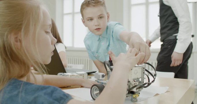 Curious kids working on a functional programable robot during robotics class at school. 4K UHD 60 FPS SLOW MOTION