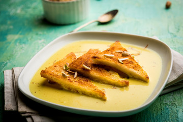 shahi tukra/tukda or Double ka meetha is a bread pudding Indian sweet of fried bread slices soaked in rabid or sweet saffron milk garnished with dry fruits, selective focus