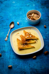 shahi tukra/tukda or Double ka meetha is a bread pudding Indian sweet of fried bread slices soaked in rabid or sweet saffron milk garnished with dry fruits, selective focus
