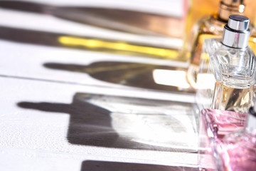 Unisex perfume bottles on white background with long hard shadows.