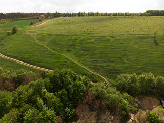 Fototapeta na wymiar Aerial view of a countryside canyone, with dirt road and green summer hill by drone, beautiful nature concept design