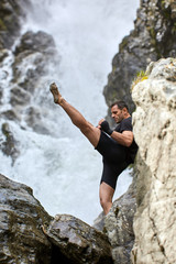 Muay thai fighter training by the waterfall