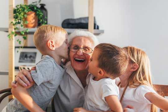 Grandchildren kissing grandmother