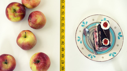 Measuring tape apple versus cake temptations red apples and cake on plate