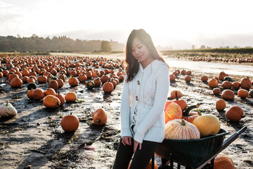 Asian Woman Holding a Pumpkin During Fall Season