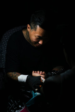 Professional asian tattooer makes a tattoo.