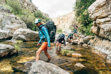 Hiker crossing mountain river
