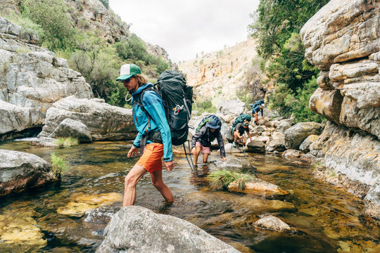 Hiker crossing mountain river
