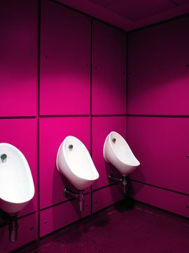 Urinals in a purple bathroom