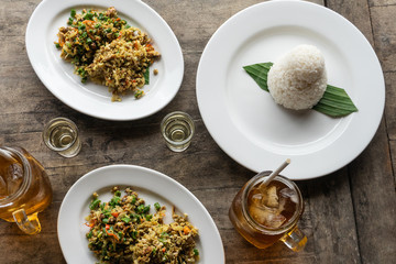 traditional Balinese food called lawar. Lawar is minced meat mixed with vegetables, long beans and spices then stirred evenly. Eat using rice and freash iced tea. Served on a wooden table