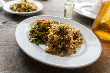 traditional Balinese food called lawar. Lawar is minced meat mixed with vegetables, long beans and spices then stirred evenly. Served on a plate at wooden table