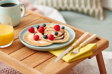 Continental breakfast with pancakes with berries and chocolate t