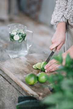 Crop woman slicing lime for drink