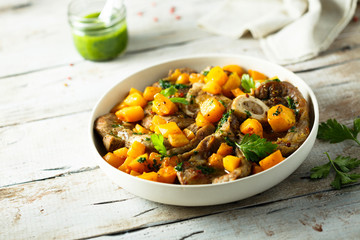 Beef on the bone with pumpkin and pesto