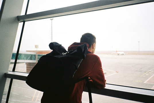 A traveler with a backpack waiting at the airport