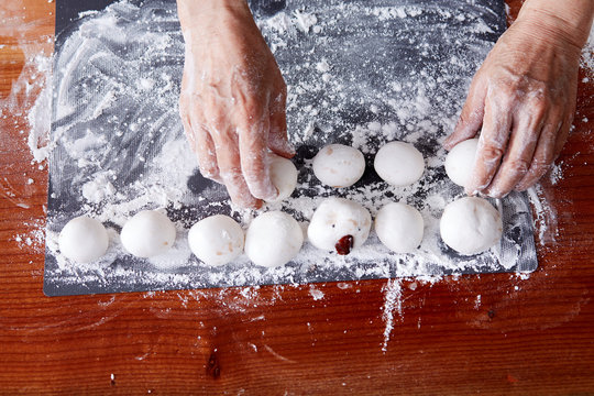 Closeup Asian old woman's hand, happy to make Chinese dessert rice dumpling at home.