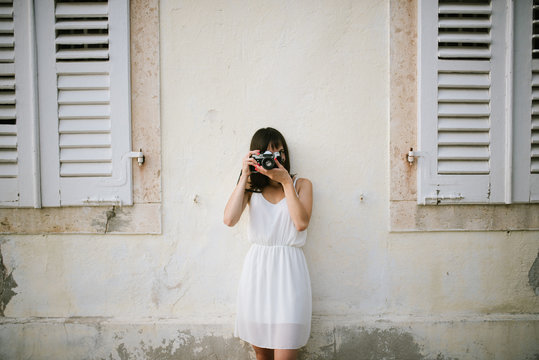 Young woman taking a photo with vintage camera