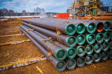 Stacked steel pipe with sunlight  reflecting on the interior walls. Stack of new metal pipes. Industrial material.