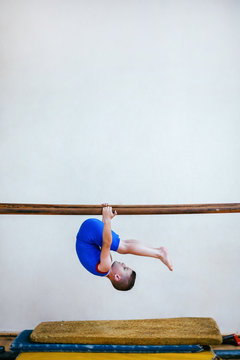 Gymnastics, young boy practicing on parallel bars