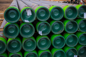 Stacked steel pipe with sunlight  reflecting on the interior walls. Stack of new metal pipes....