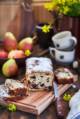 Delicious homemade chocolate and pears loaf cake on rustic wooden background