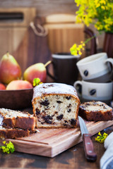 Delicious homemade chocolate and pears loaf cake on rustic wooden background