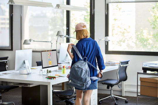 Executive Carrying Backpack While Standing By Desk