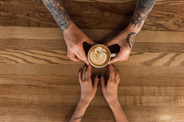 Crop shot of man giving coffee to girl
