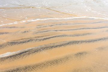 Sea beach clean sand pattern made by sea waves after gone in sunny day.