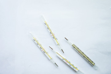 Four mercury thermometers on a white background