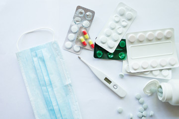 Medicaments on a white background, pills, thermometer, inhaler