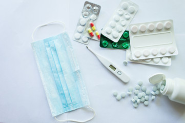 Medicaments on a white background, pills, thermometer, inhaler