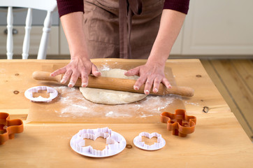 female hands rolling out dough with a rolling pin