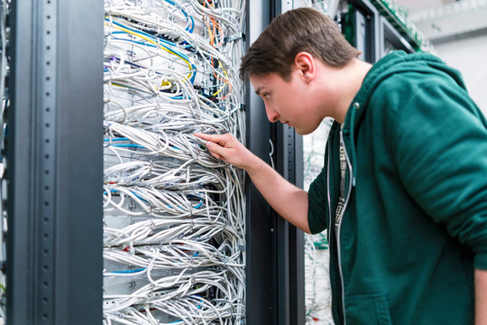 Teenager working with cables in server room