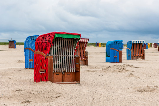 Germany, Nessmersiel, hooded beach chairs on sandy beach
