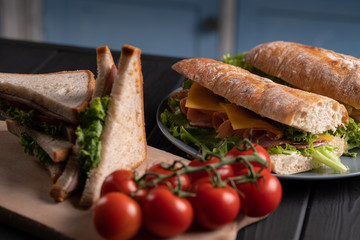 Different sandwiches,toast with vegetables and cheese. Fresh baguette. Breakfast. Black table. Kitchen