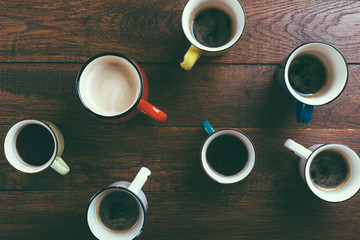various mugs of coffee, wooden table, top view