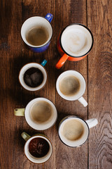various mugs of coffee, wooden table, top view